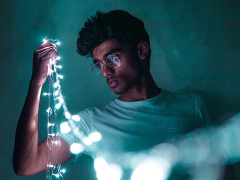 young man with string of lights