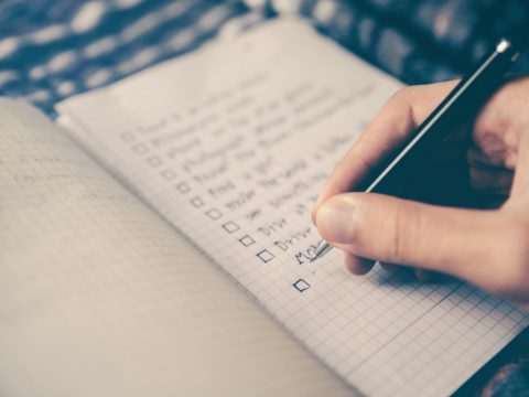 person writing to do list