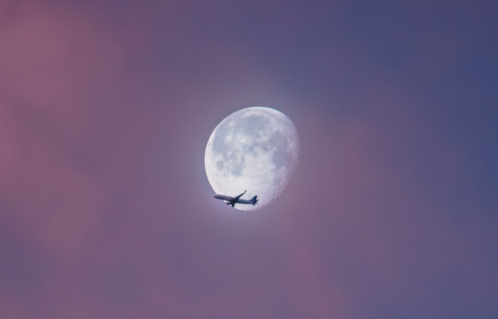 airplane against the moon