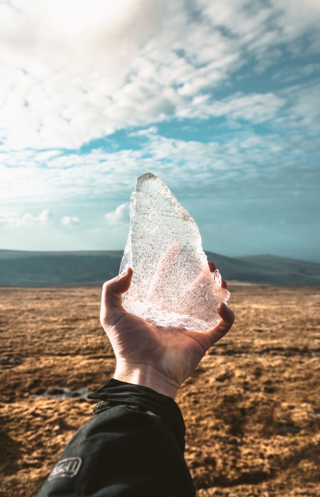man holding ice in the desert